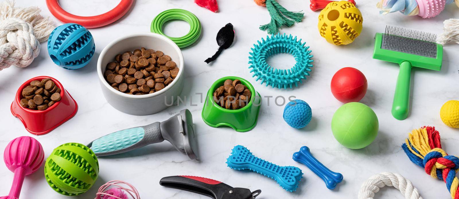 Pet care concept, various pet accessories and tools, toys, balls, brushes on white marble background, high angle