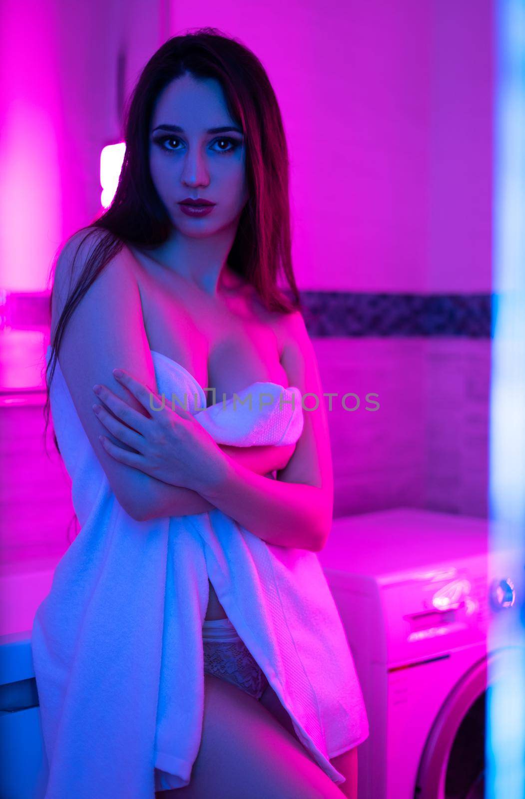 the sexy girl with long hair in a white towel in the bathroom with neon light
