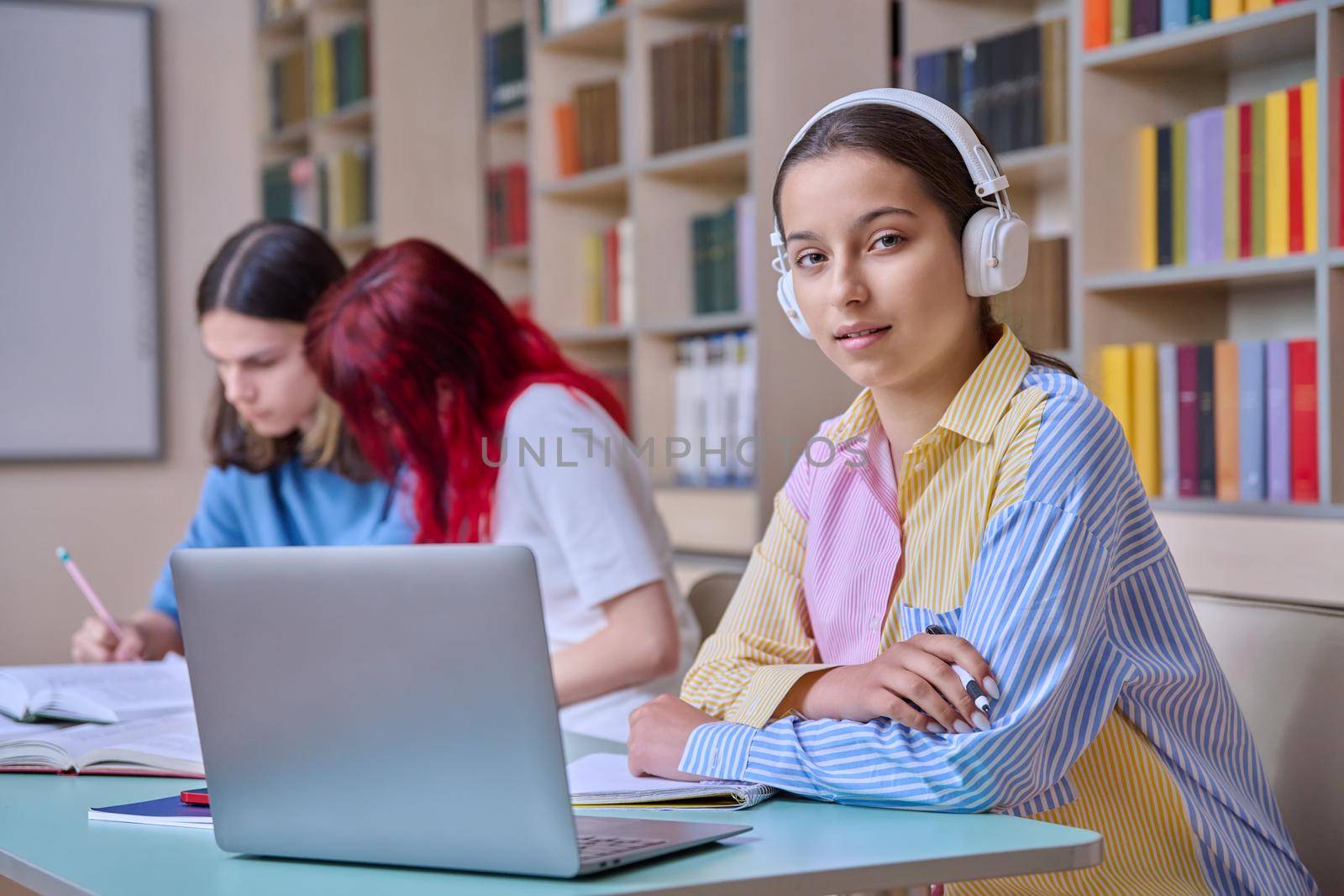 Group of teenage students study in school library by VH-studio