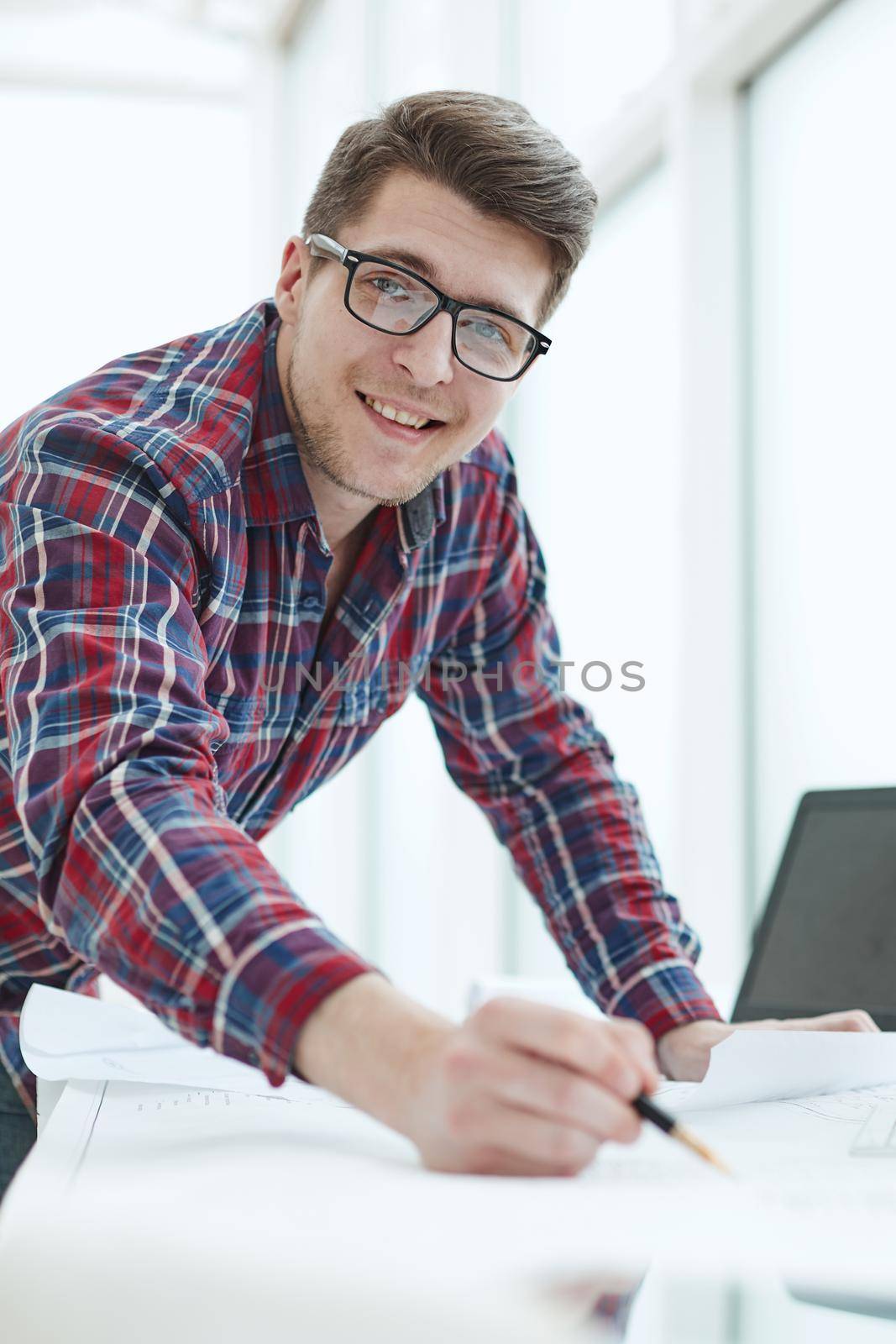 Rear view of a young businessman using laptop at office desk