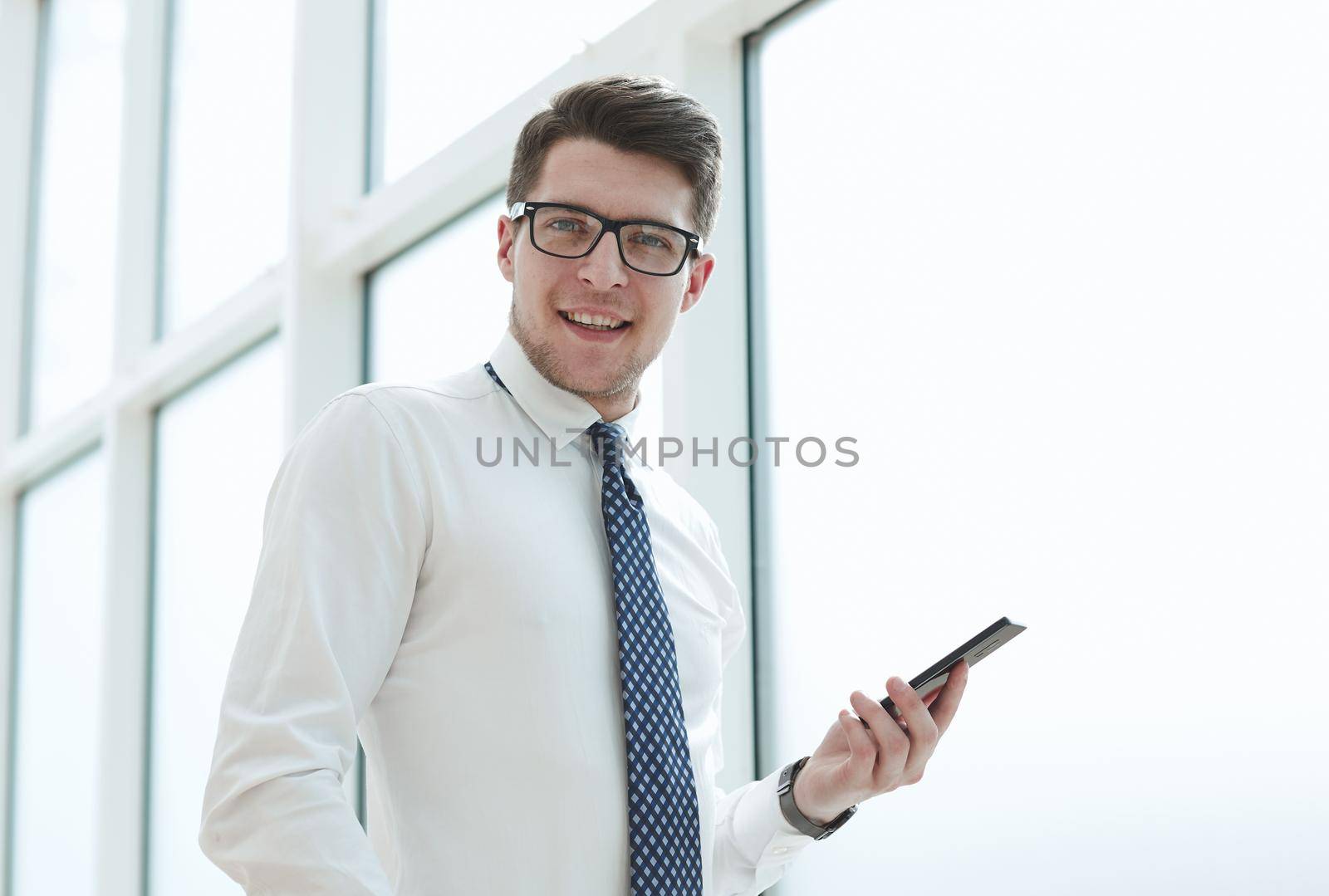 Businessman using smart phone in blurred office space background and copy space
