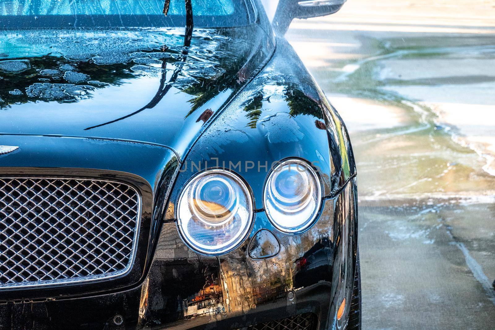 auto detailer washing luxury high end car by digidreamgrafix