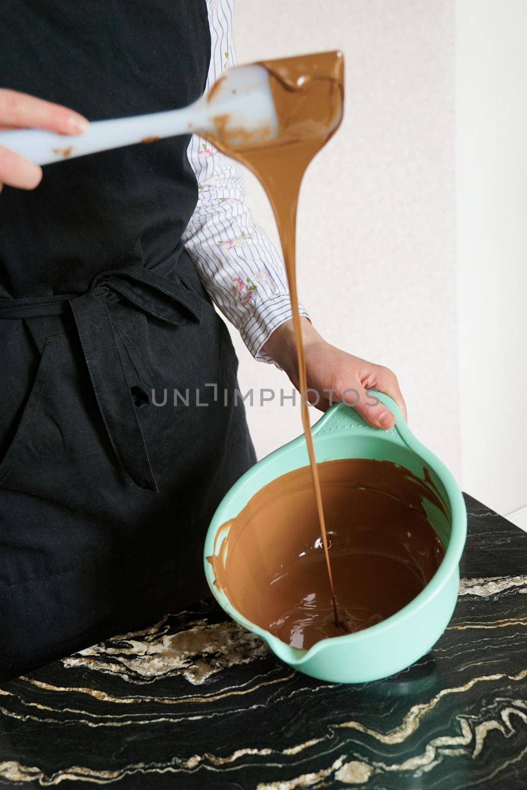 Closeup - confectioner - woman stirs chocolate for making homemade chocolates by natali_brill