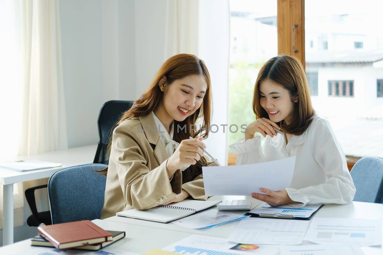 Negotiation, Analysis, Discussion, Portrait of an Asian woman economist and marketer pointing to a financial data sheet to plan investments to prevent risks and losses for the company.