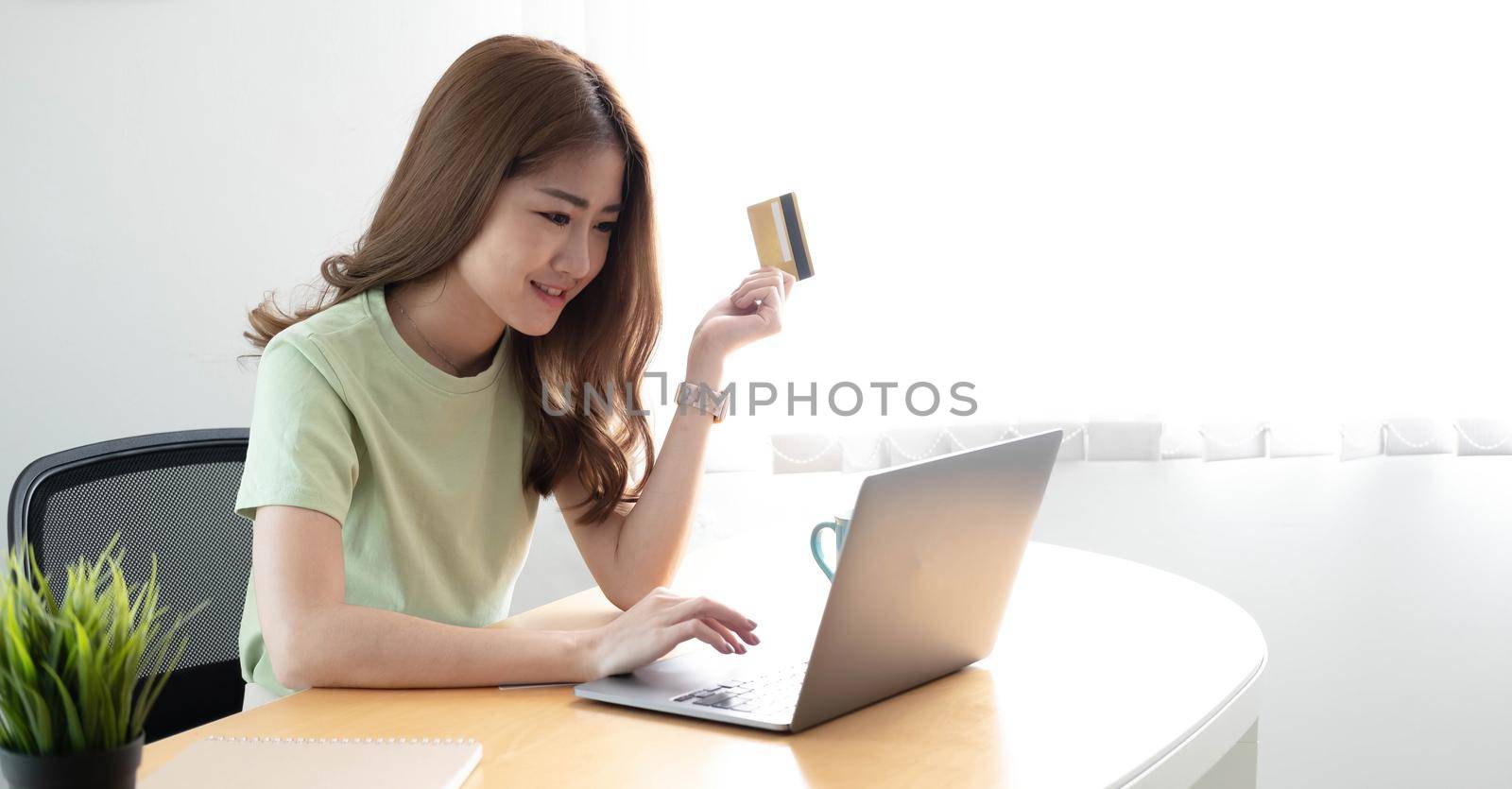 Online payment woman's hands holding a credit card and using laptop computer for online shopping.