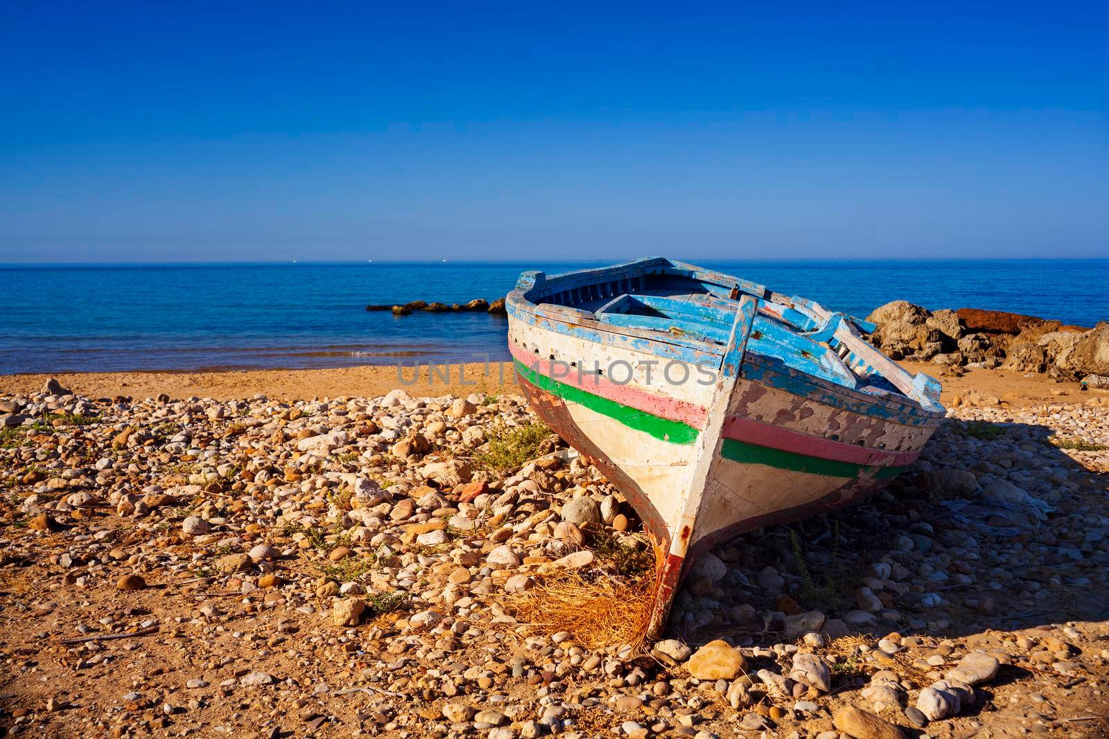 Broken migrant boat stranded on the beach by bepsimage