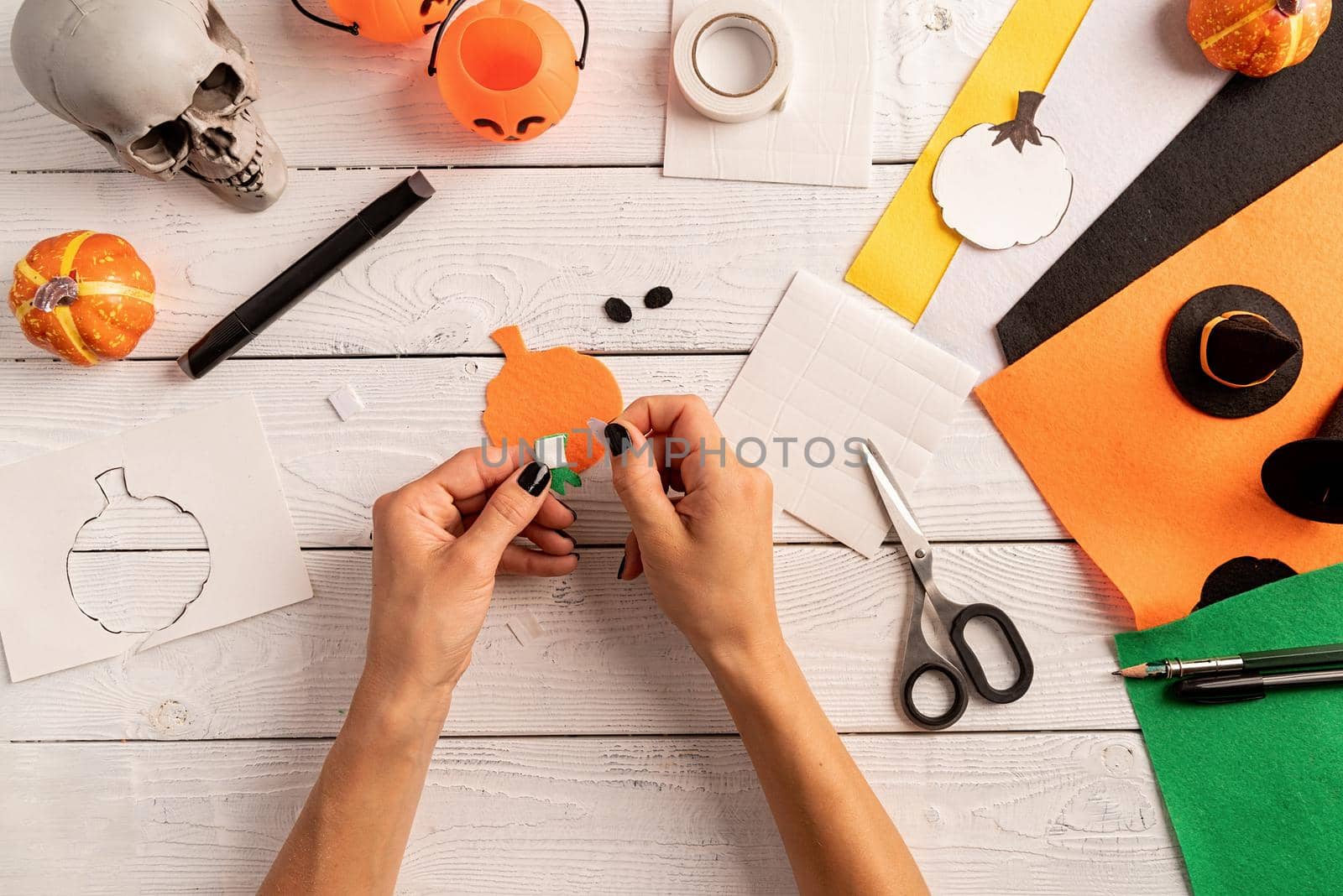 Step by step instruction of making halloween bookmark DIY pumpkin craft. Step 5 - stick together. Top view flat lay by Desperada