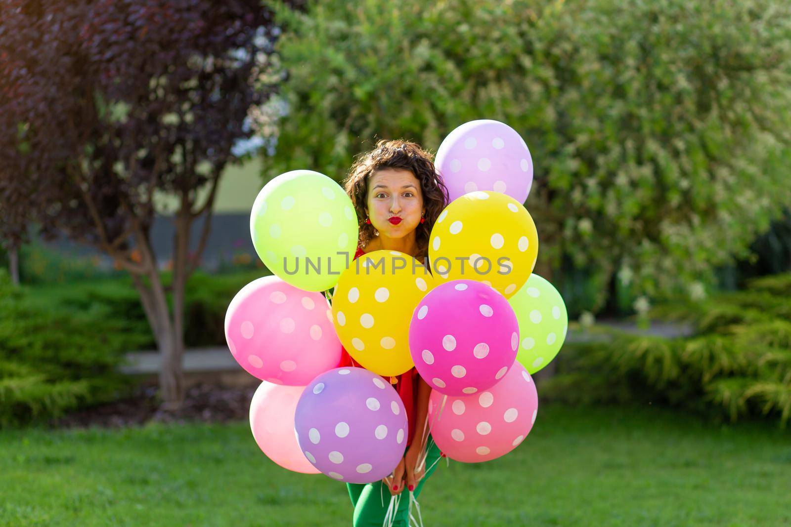 Young bright joyful brunette girl with colorful balloons. Happy lifestyle.