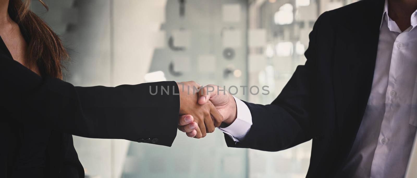 Businesspeople shaking hands after investment deal, finishing up a meeting. Teamwork and partnership concept. by prathanchorruangsak