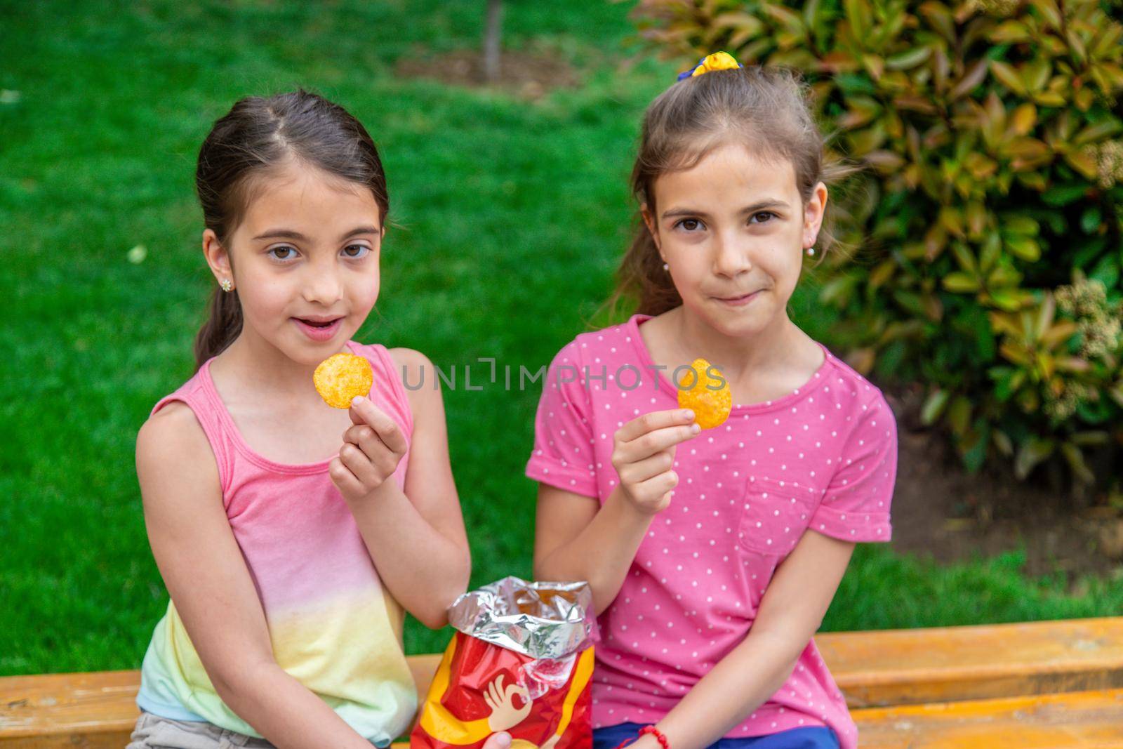 Children eat chips in a friend's park. Selective focus. Kids.