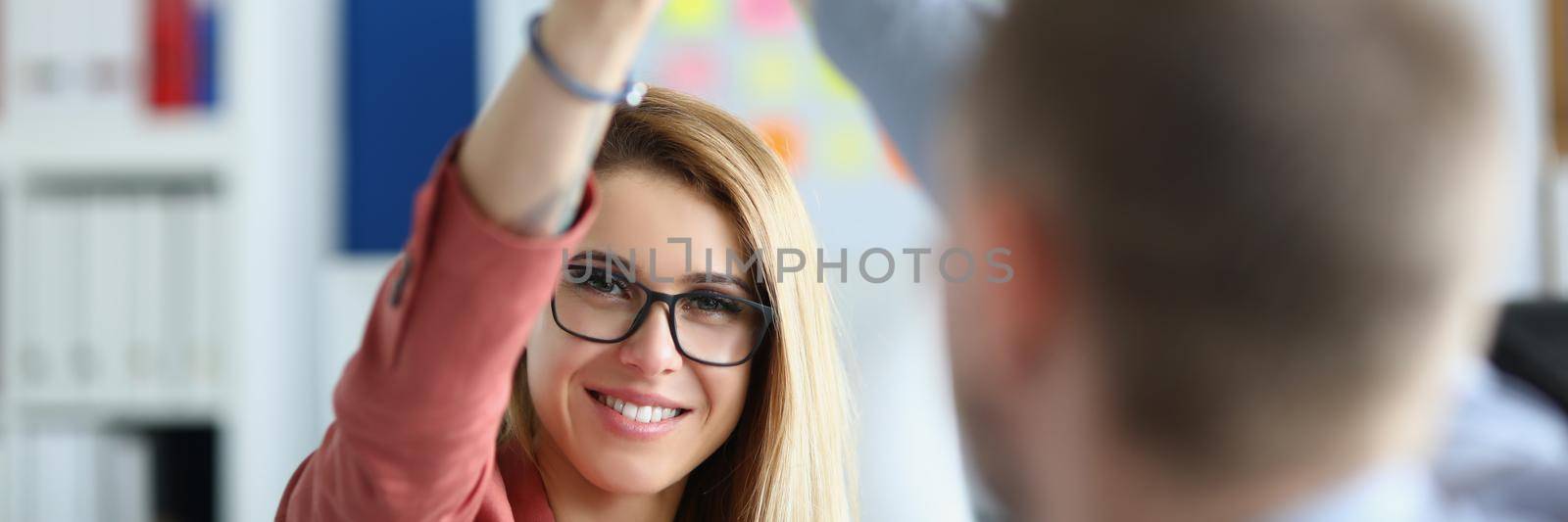 Portrait of woman giving high five to partner in work, celebrating successful teamwork, finish of project. Businesspeople happy about accomplished work. Business concept