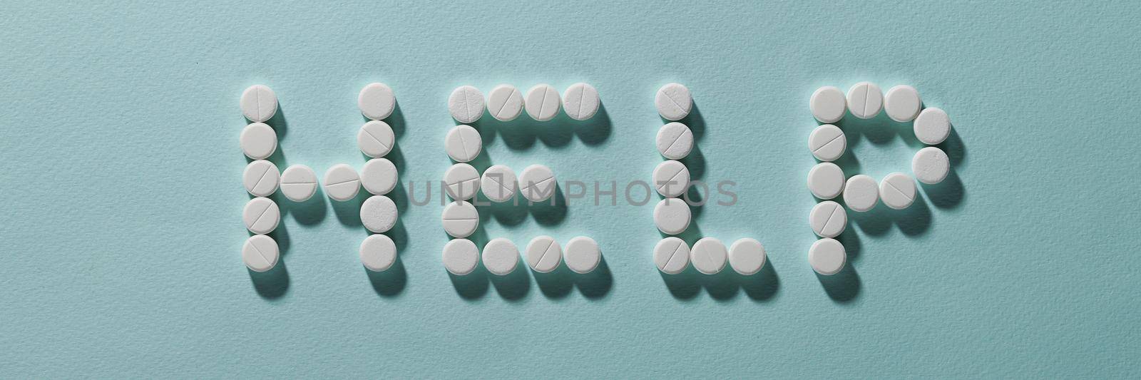 Top view of help lettering made with pills, drug prescription for treatment, pharmaceutical medicament, oral tablets. Medicine help, healthcare, illness, support organism concept