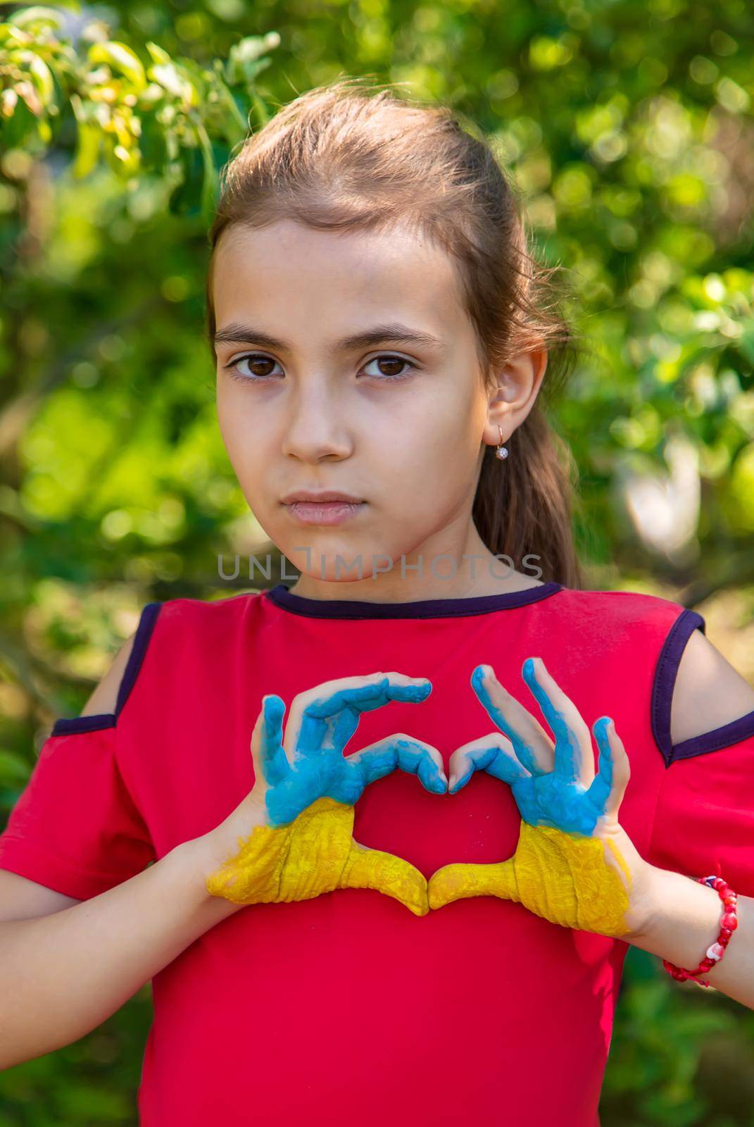 A child with the flag of Ukraine painted on his hands. Selective focus. Kid.