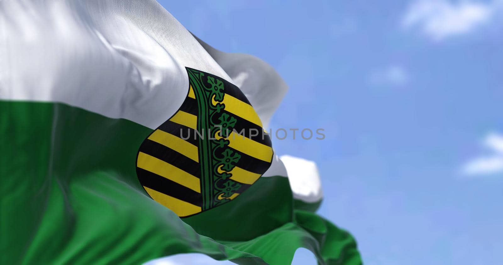 The flag of Saxony waving in the wind on a clear day. Saxony is a landlocked state of Germany