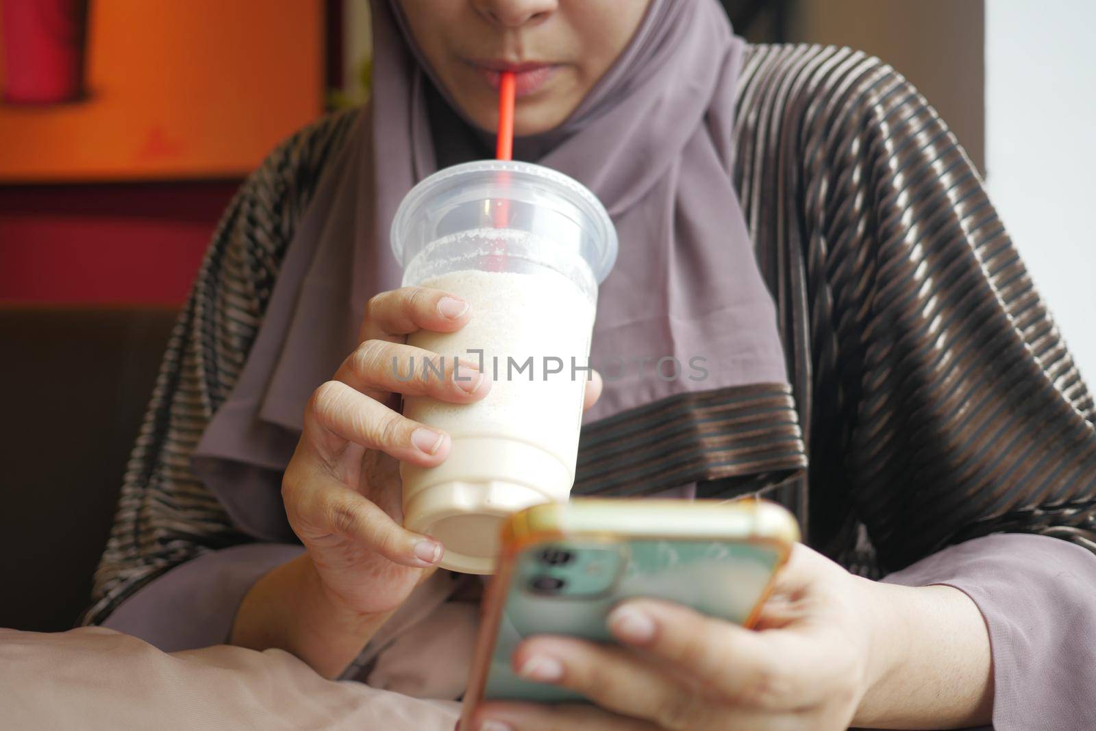 young women drinking banana milk shake at cafe .