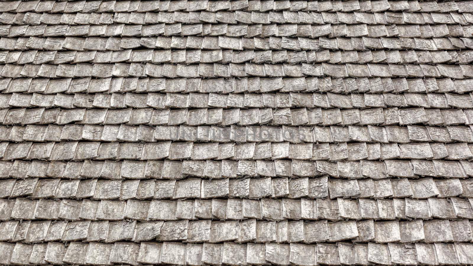 Weathered wooden shingles on a roof. wooden roof tile of old house