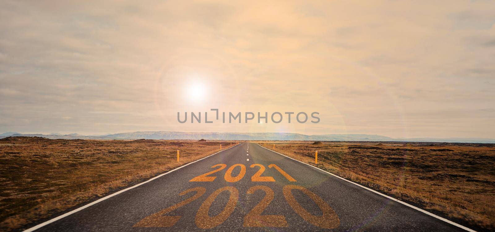 The word 2021 written on highway road in the middle of empty asphalt road by driver-s