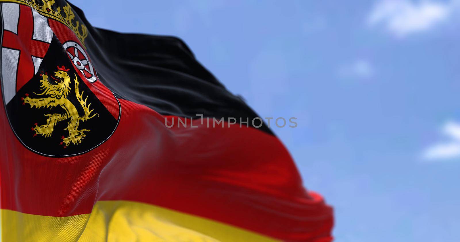 The flag of Rhineland-Palatinate waving in the wind on a clear day by rarrarorro