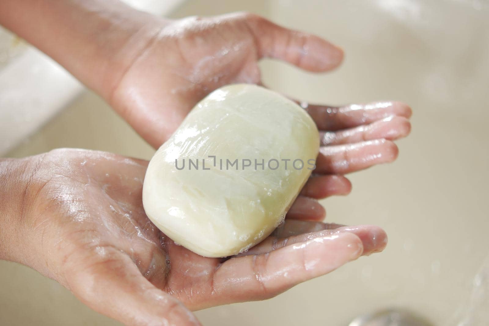 young man washing hands with soap warm water.