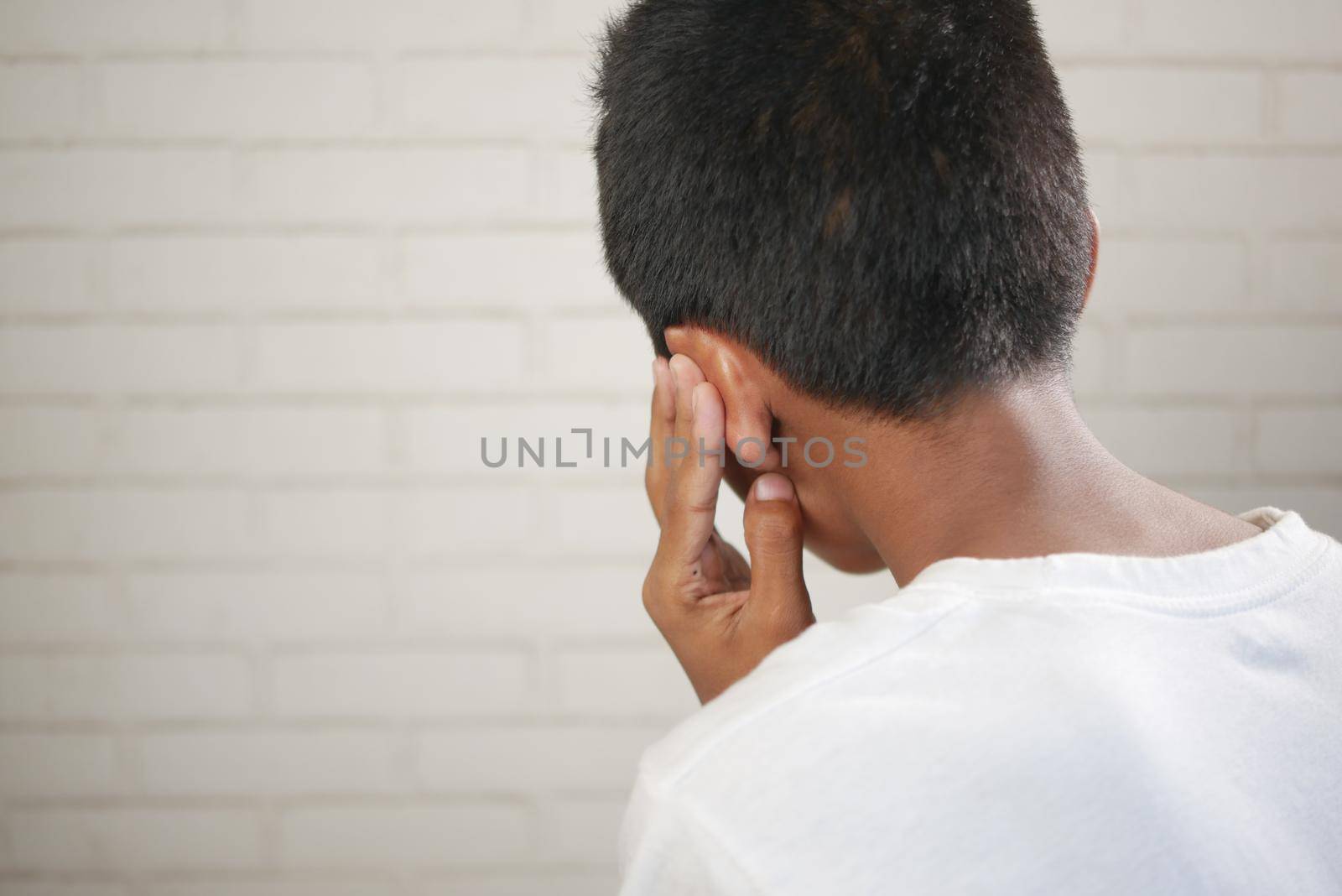 teenage boy having ear pain touching his painful ear