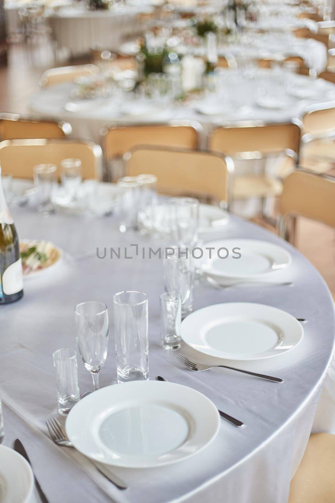 Table set for an event party or wedding reception. Banquet table design. Festive table setting. Glass and plates on the table.