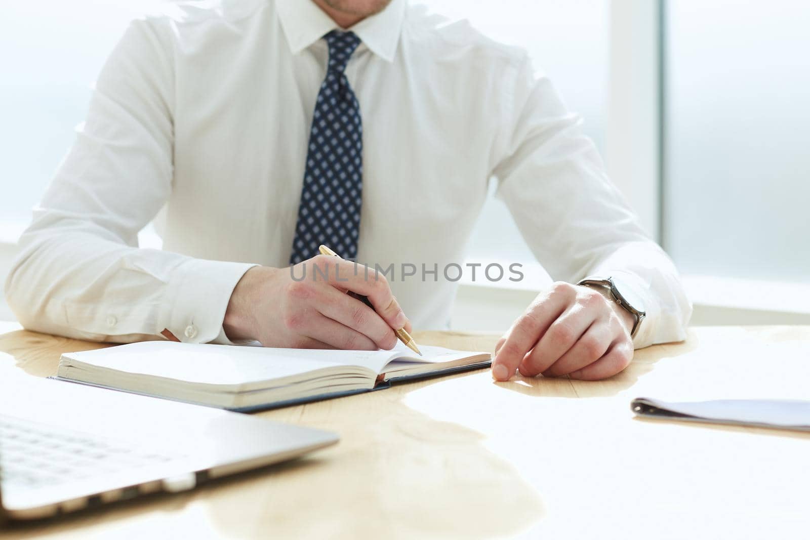 Closeup of business man writing form on clipboard at office by Prosto