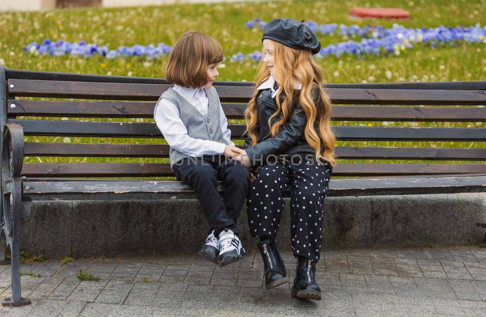 children sit on a bench and look at each other