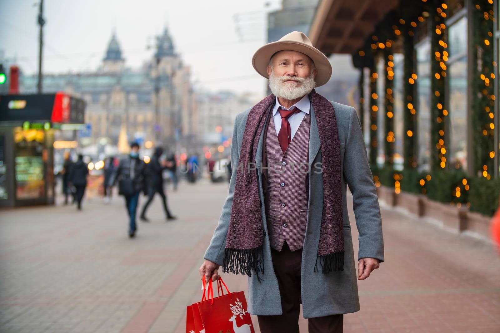 bearded grandfather with a handbag walks on the street