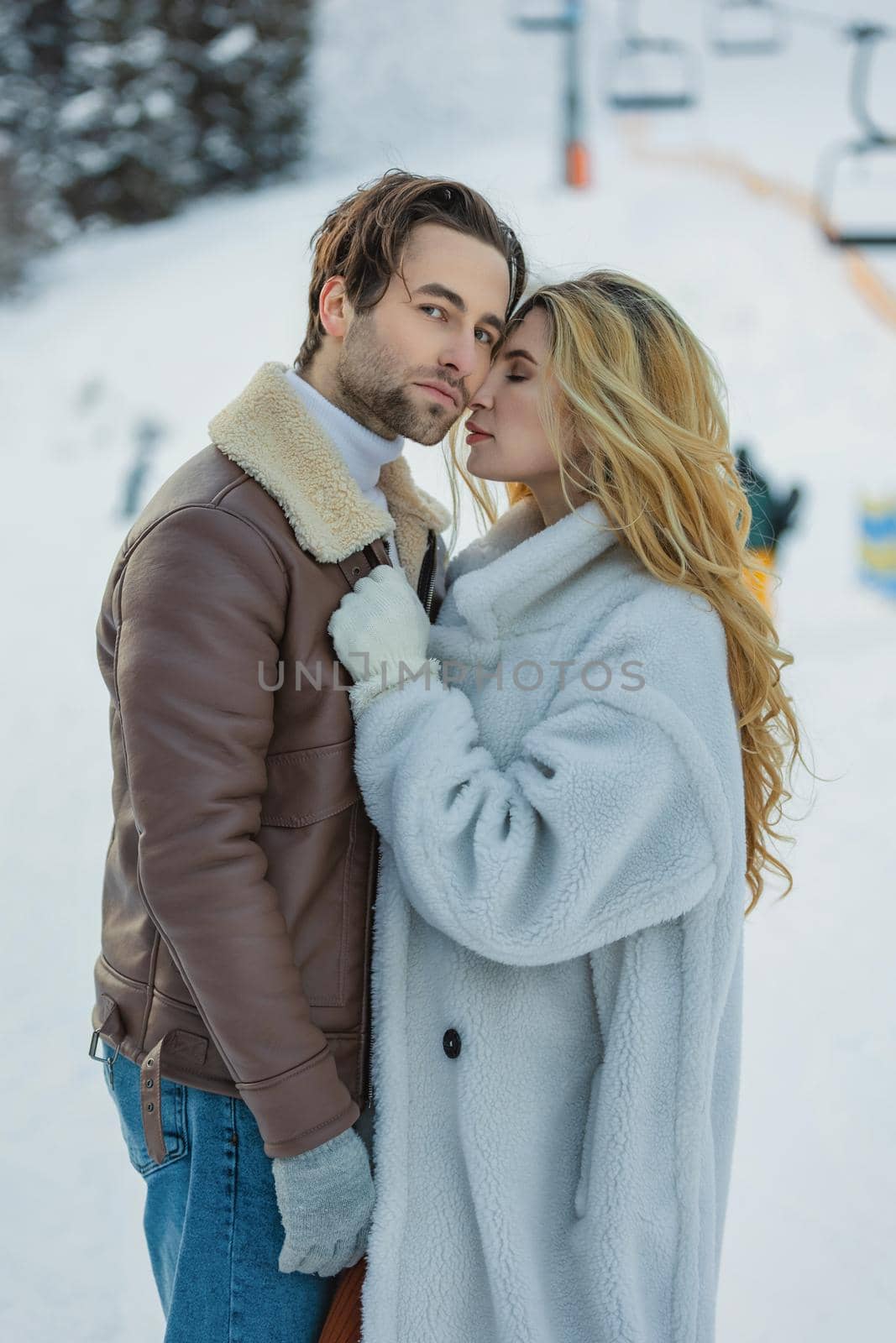 beautiful couple hugging in winter on the background of a snowy mountain