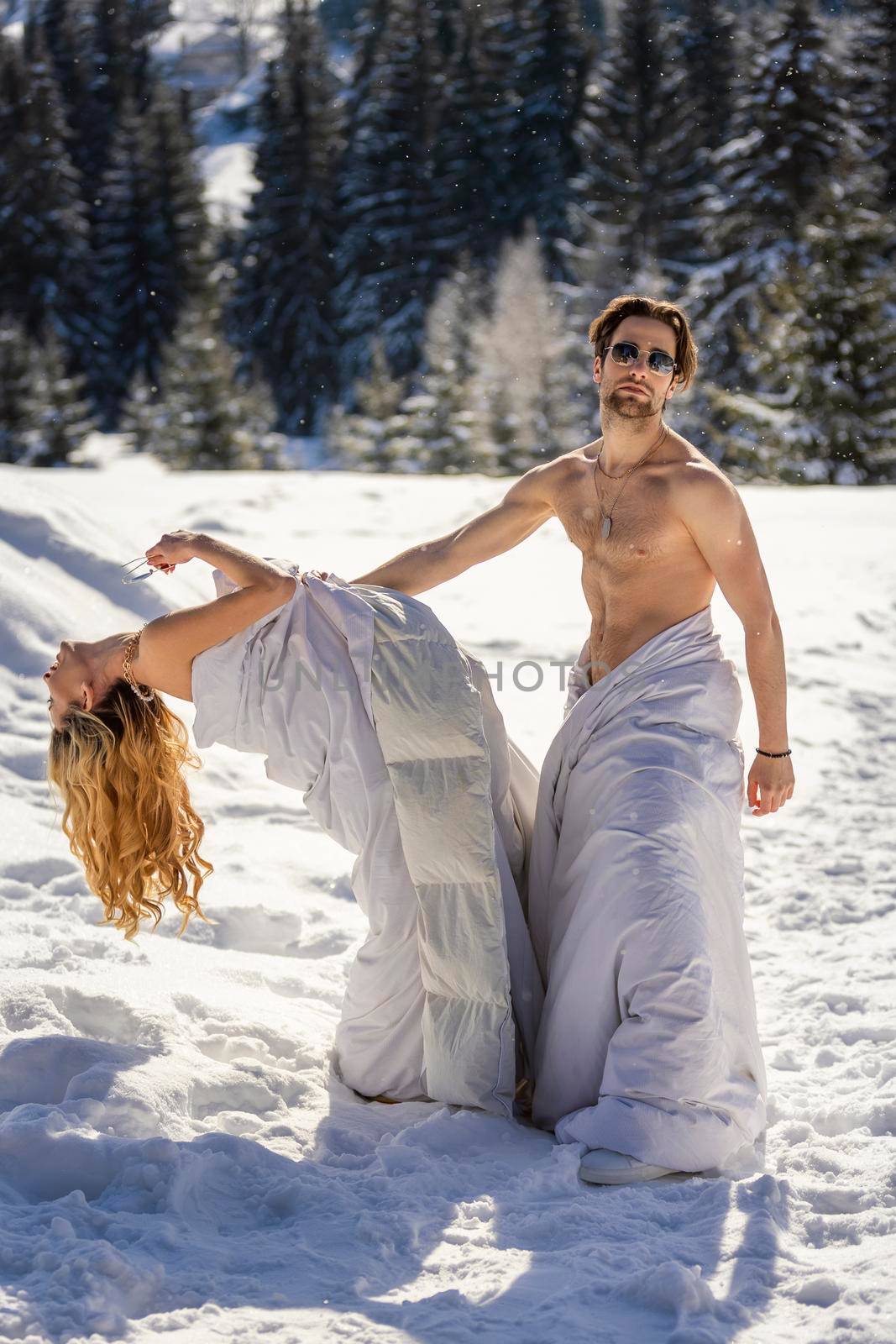 couple in blankets in winter against the background of mountains
