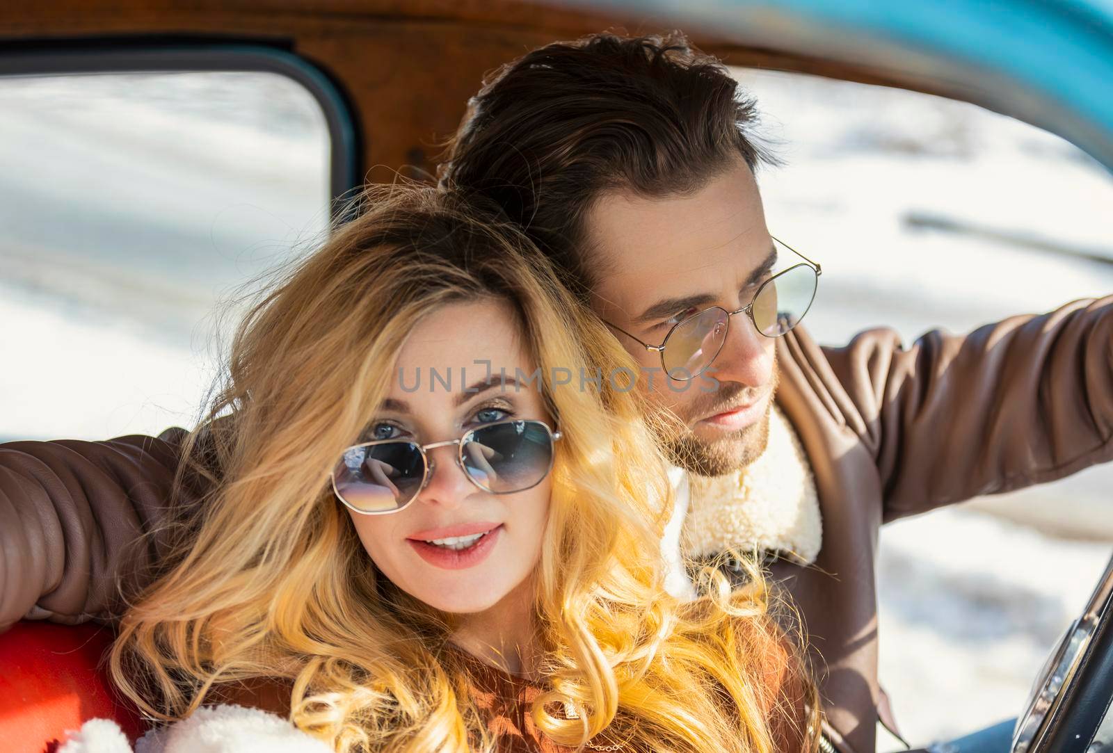 couple wearing sunglasses sitting in the car