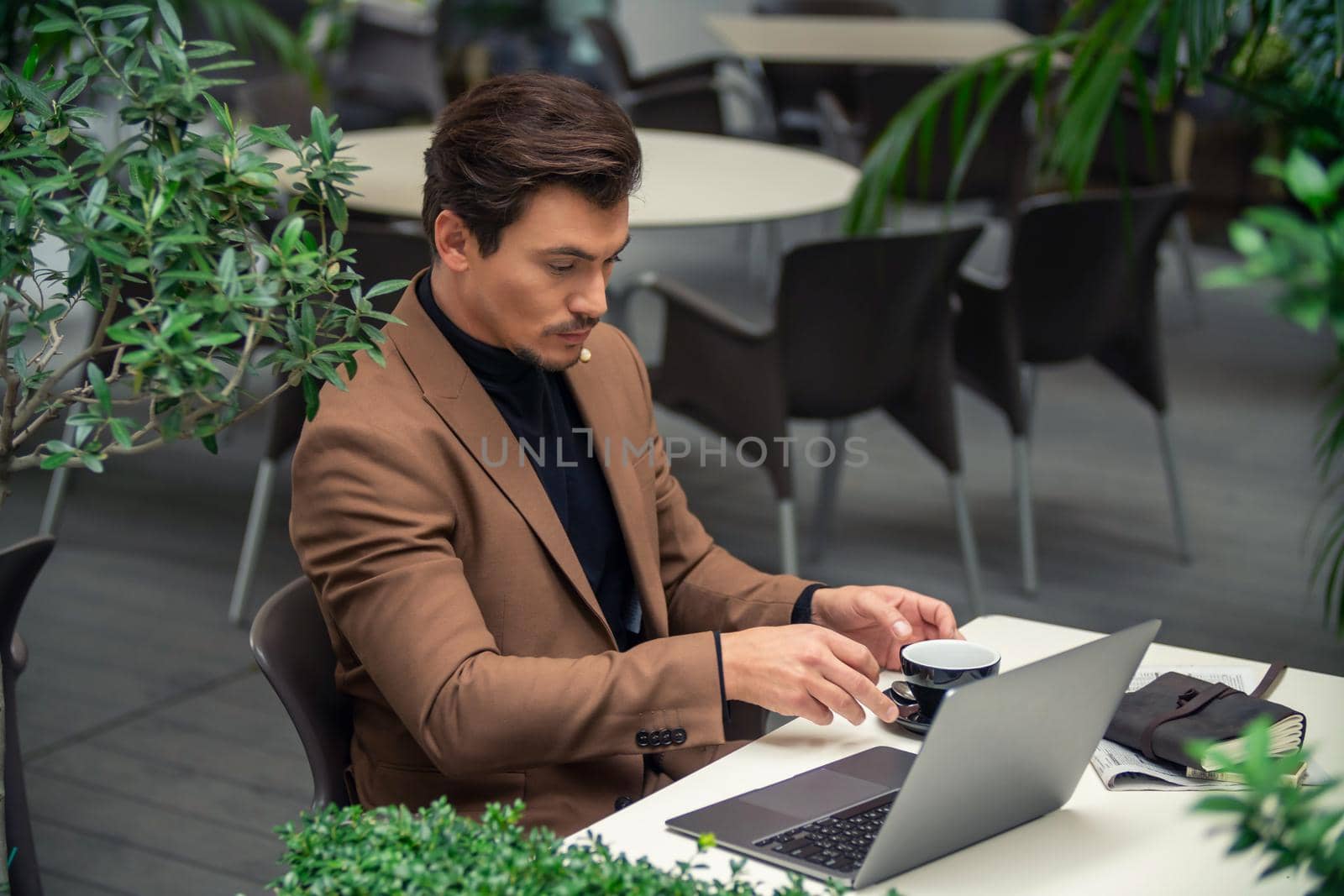 businessman sitting at a table in a cafe with a laptop