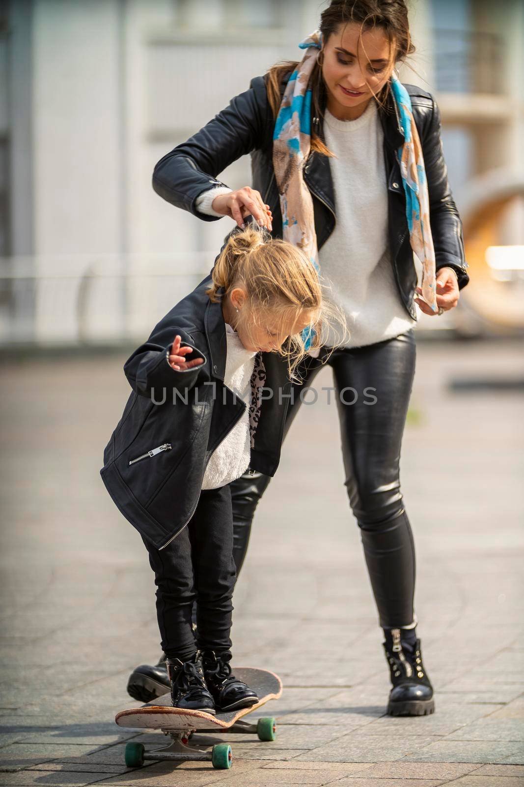 child and mom ride a skateboard