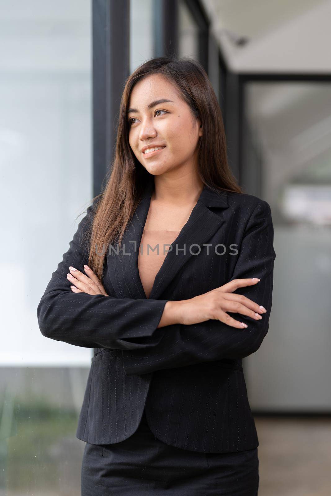 Portrait working woman asian wearing a black suit, smiling, Crossed hands looking outside with confidence.