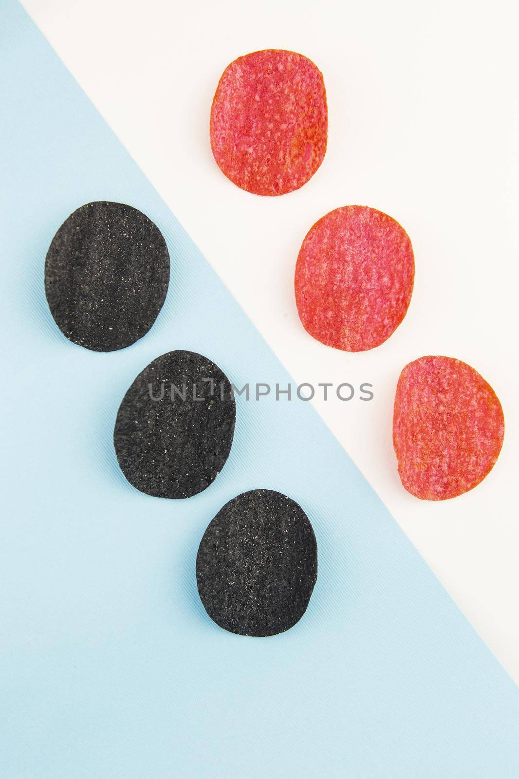 Red and black potato chips with salt, chili pepper. Isometric drawing. Chips background on white and blue background. by sfinks