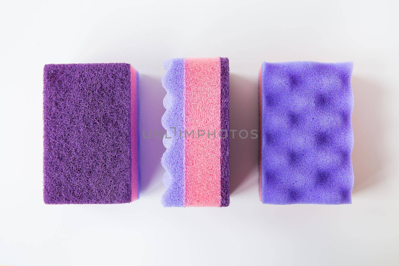 A group of multi-colored kitchen sponges. Set of colorful sponges for the kitchen. Cleaning and cleaning concept. View from above. by sfinks