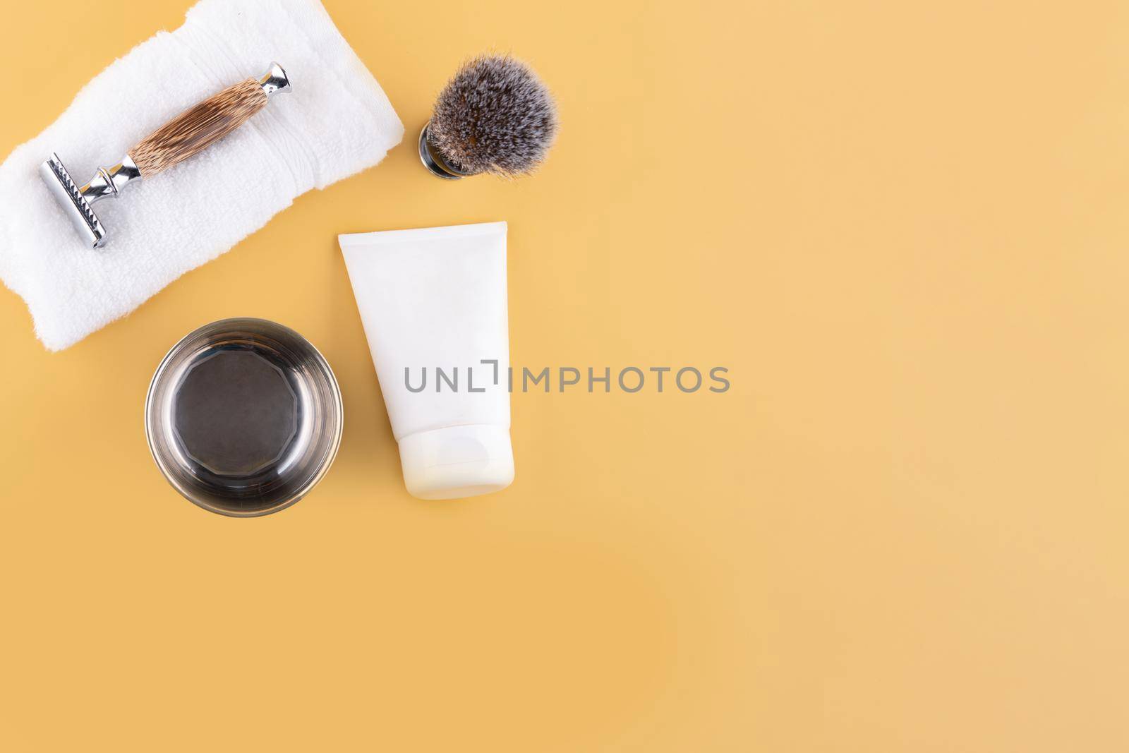 vintage razors, foam, towels, and brush on a yellow background. View from above Space for text