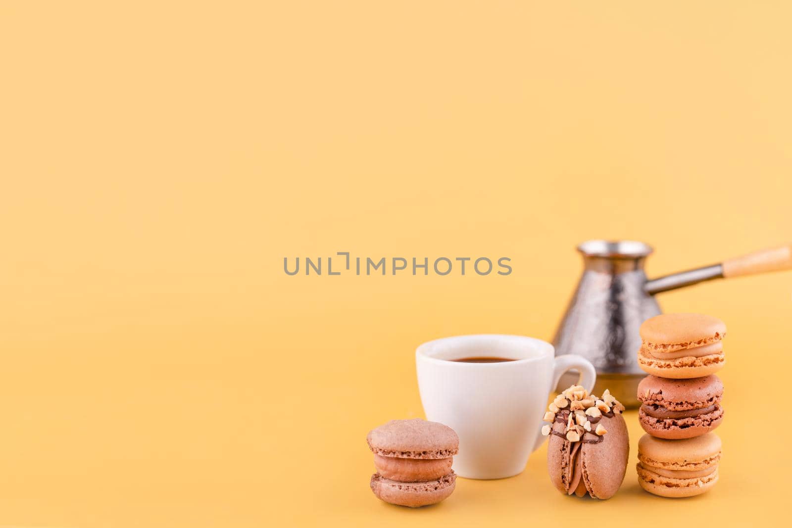 Close-up of Americano coffee, jezva, coffee pot and almond cookies on a yellow background by Iryna_Melnyk