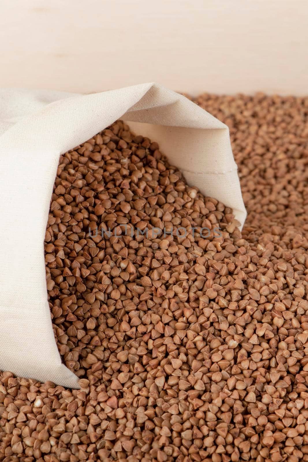 Buckwheat harvest. Poor agricultural harvests, food shortages, world hunger. A bag of buckwheat on a brown background with a white down arrow. by SERSOL