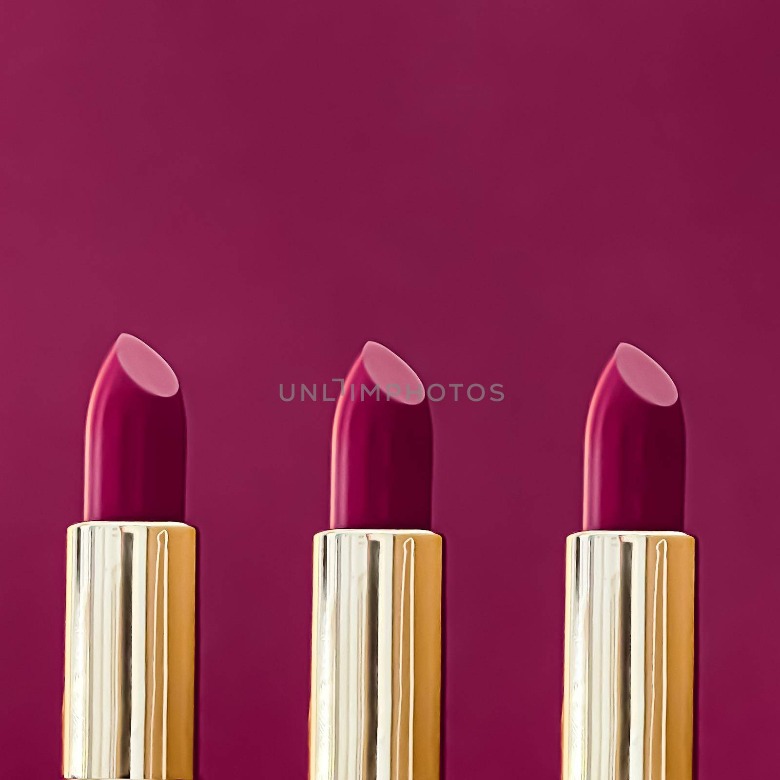 Purple lipsticks in golden tubes on colour background, luxury make-up and cosmetics for beauty brand product design concept