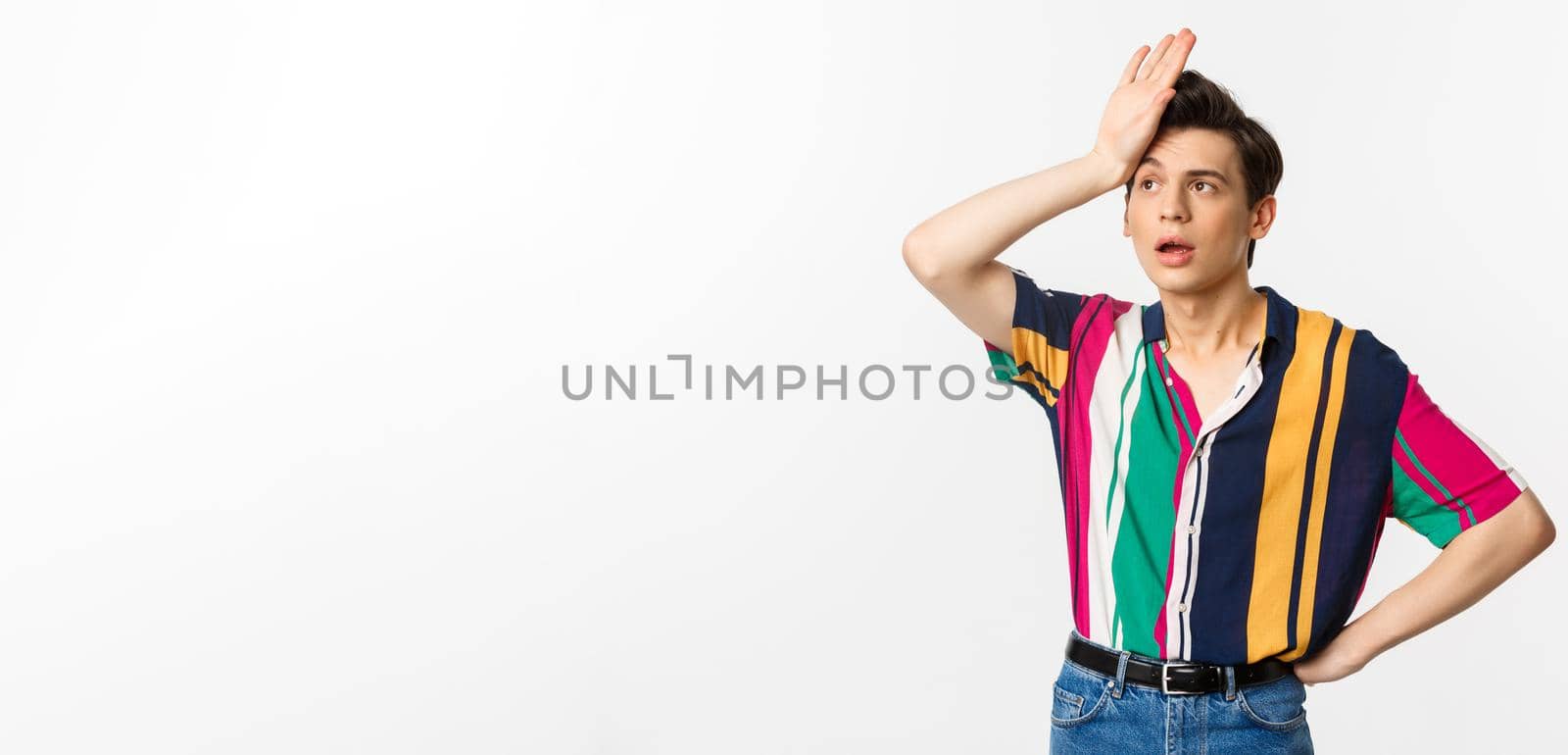 Tired queer man facepalm and sighing distressed, standing against white background troubled by Benzoix