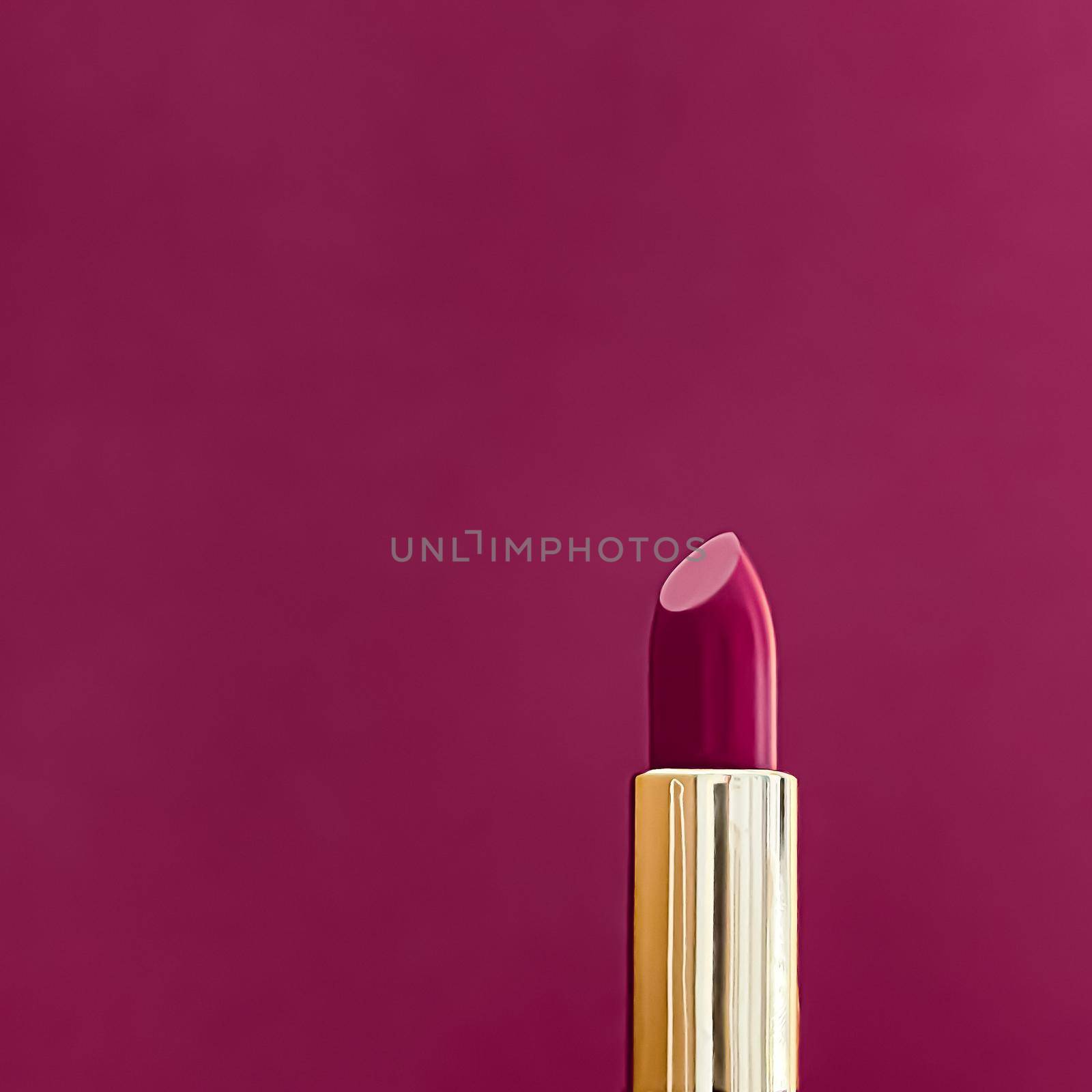 Purple lipstick in golden tube on colour background, luxury make-up and cosmetics for beauty brand product design concept