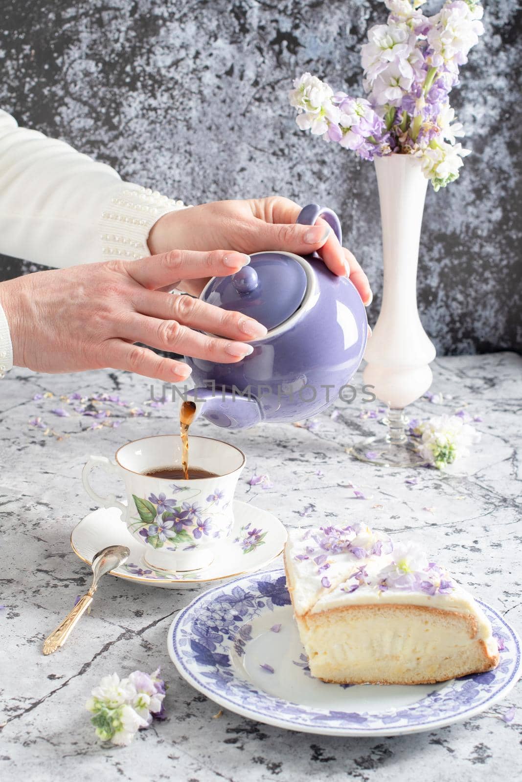 still life with black tea and cheese cake, spring bouquet of delicate lilac flowers. High quality photo