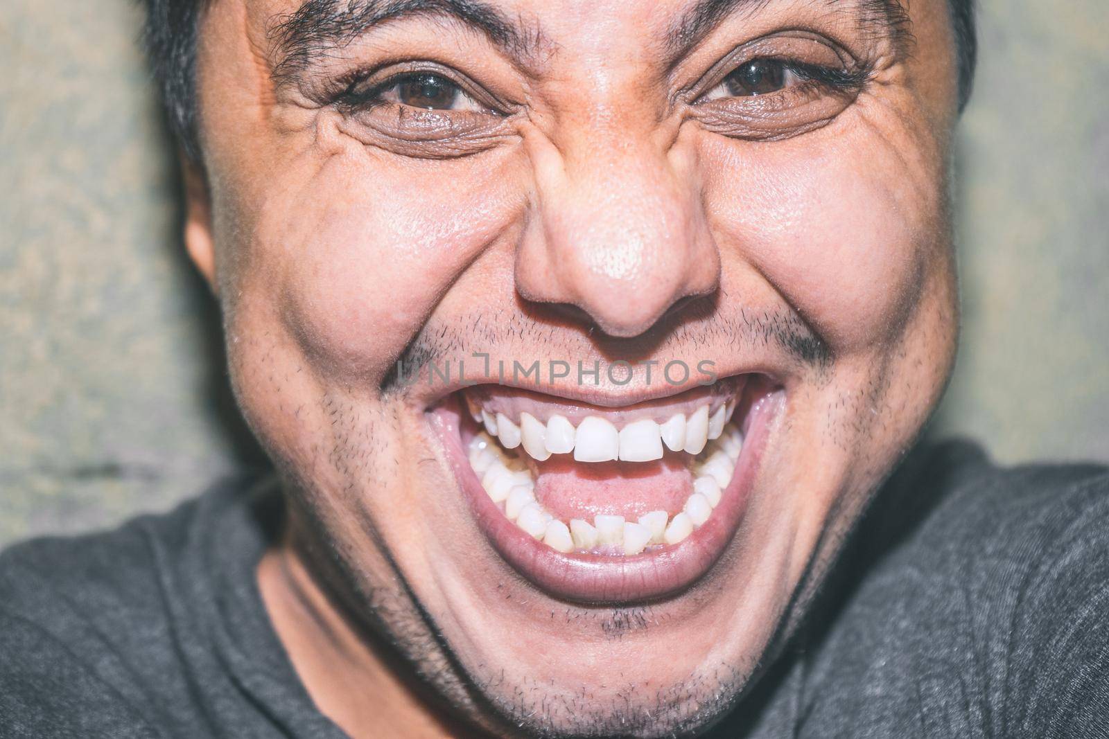 Moody portrait of a Latin man smiling by cfalvarez