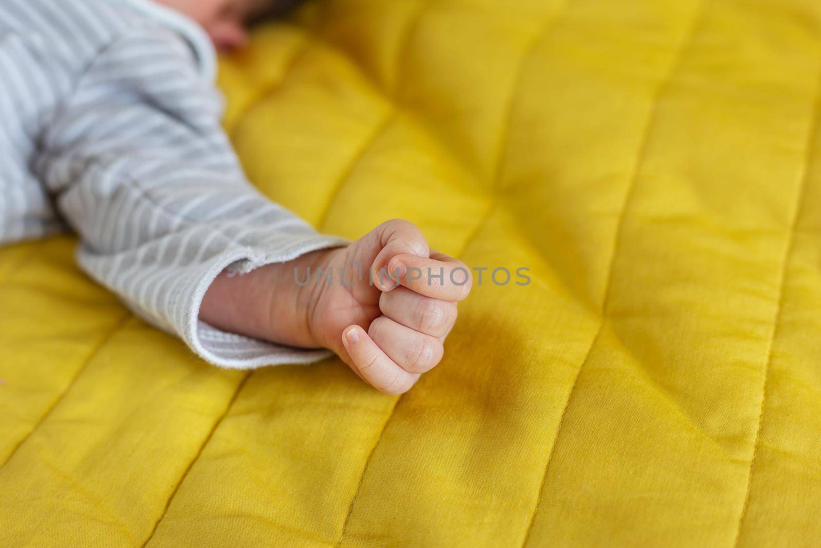 Little hands of a newborn baby, holding a fist, little fingers. The first month of a baby's life