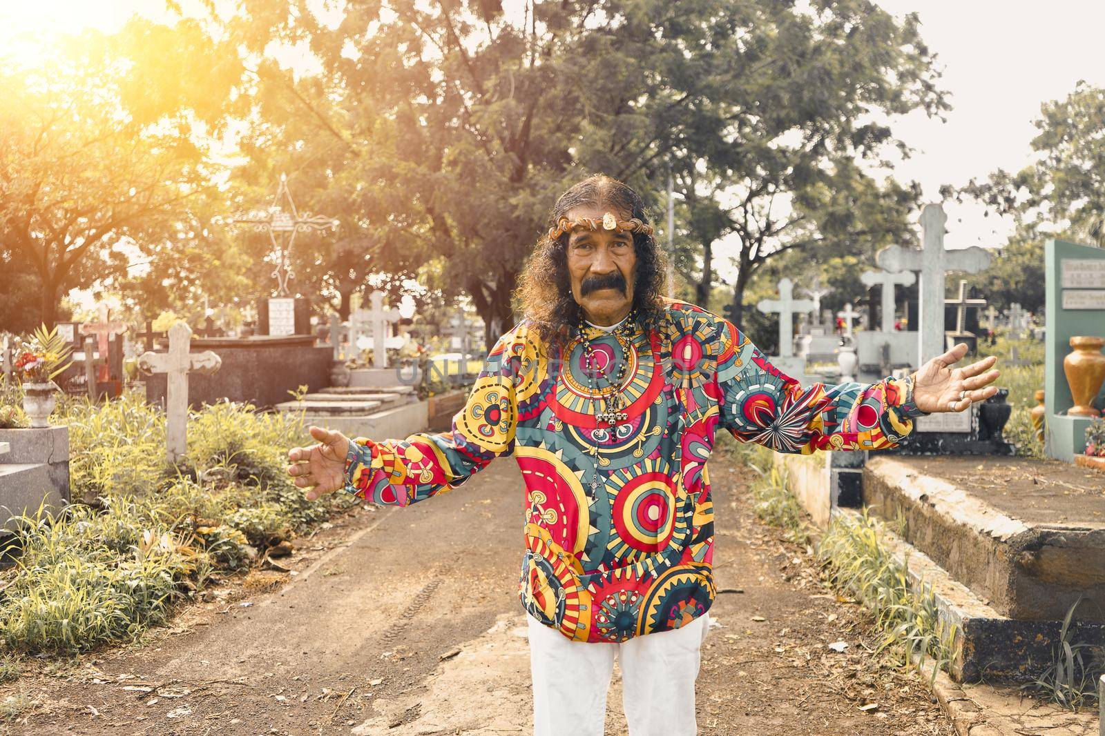 Elderly imitator of Christ with psychedelic clothing in a cemetery in Managua Nicaragua
