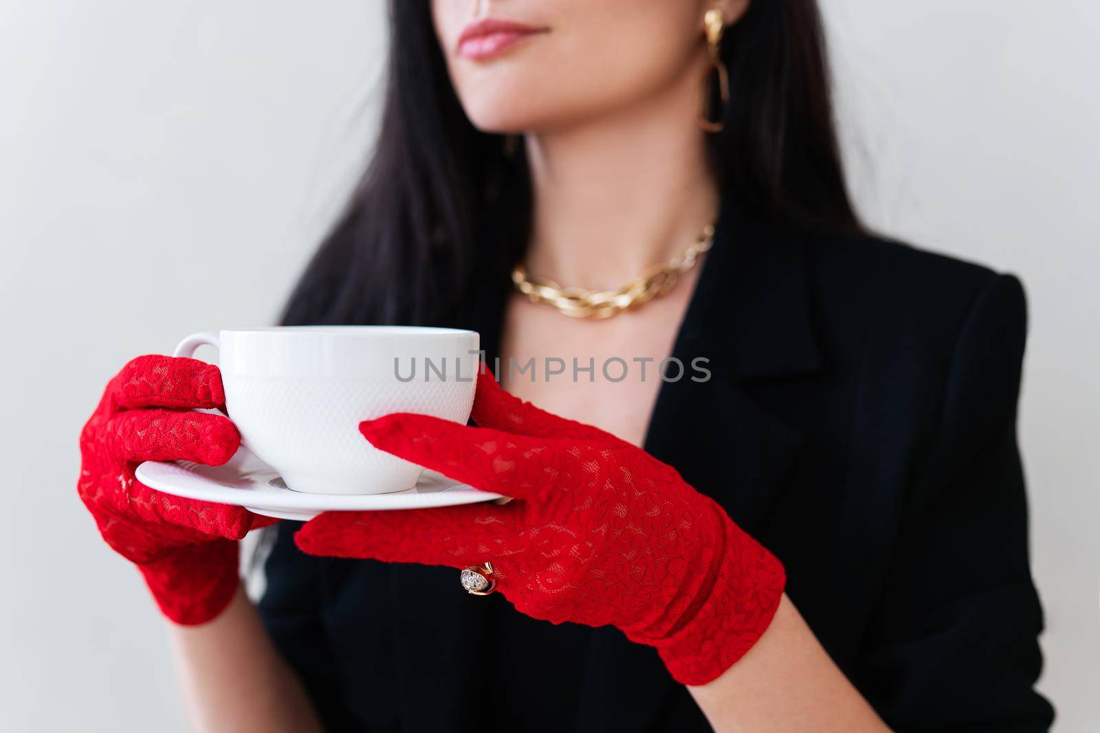 Vintage photo of a glamorous girl in vintage lace red gloves holding a white cup of coffee. by sfinks