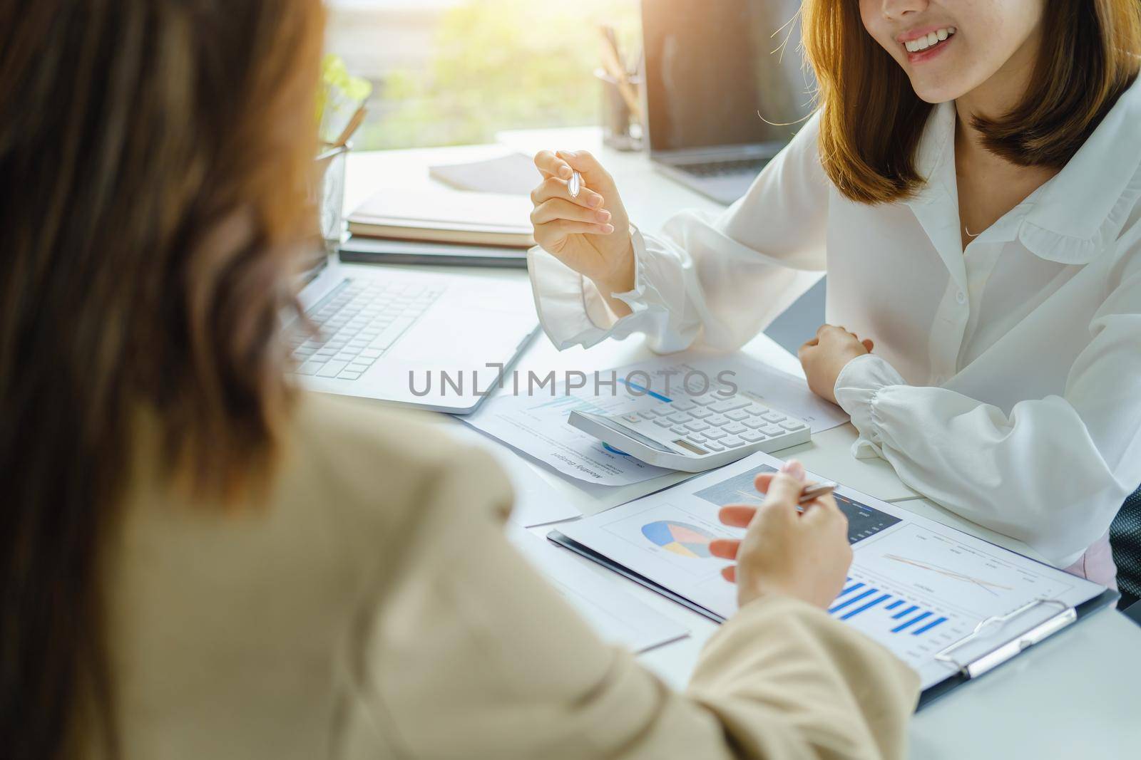 Negotiation, Analysis, Discussion, Asian woman economist and marketer pointing to a financial data sheet to plan investments to prevent risks and losses for the company.