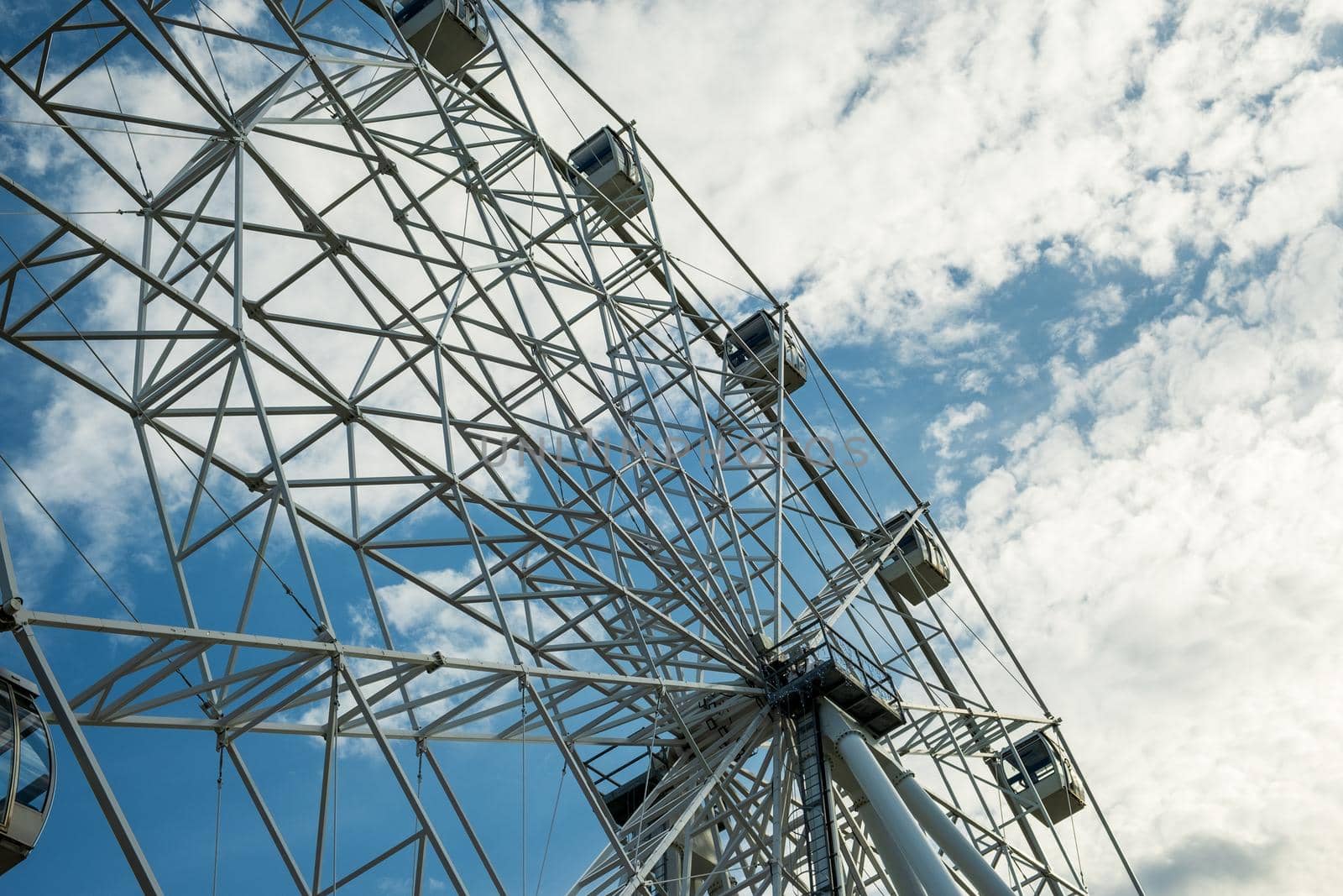 Bottom view of the ferris wheel and the sky with clouds. by OlgaGubskaya