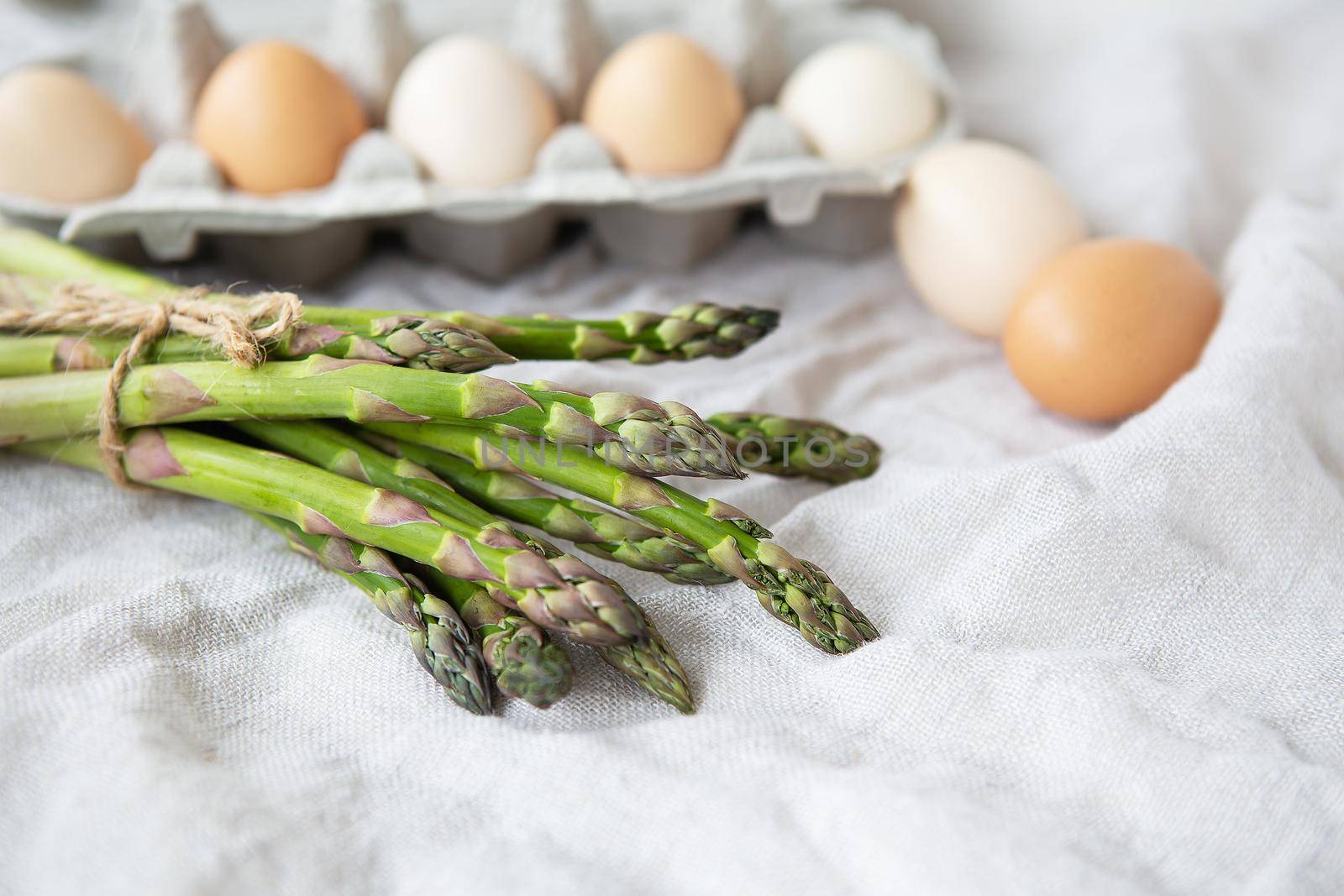 Asparagus and eggs on a fabric linen background. The concept of a healthy and healthy breakfast. Place for an inscription. by sfinks